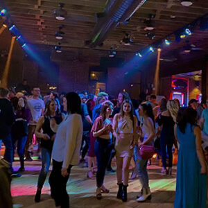 Joyful dancers dressed elegantly, smiling and enjoying live music and entertainment on the dancefloor at Portside Stillwater.