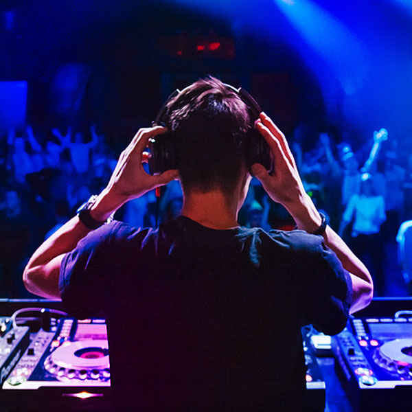 Energizing anticipation as the DJ prepares to drop the beat in front of a massive crowd at Portside Nightclub.